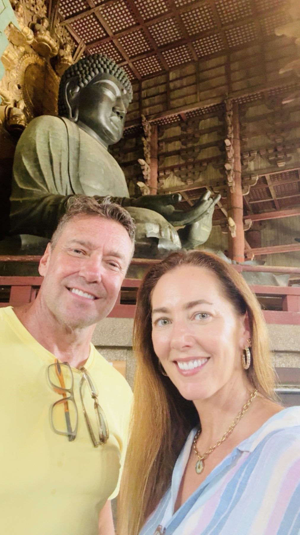 Two parents smiling in front of the Great Buddha inside Todai-ji