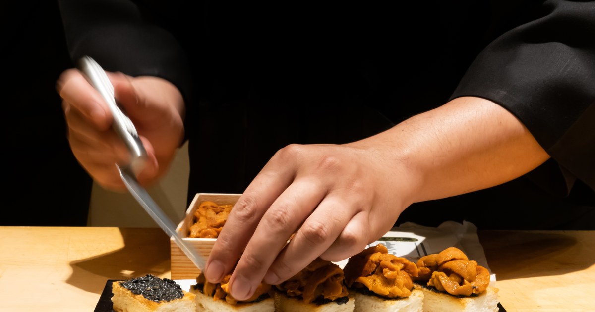 A sushi chef's hands at work behind a small counter