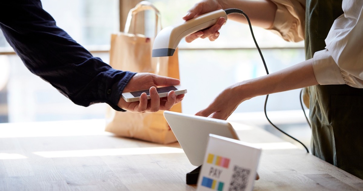 A customer paying by smartphone QR code at a Japanese shop counter
