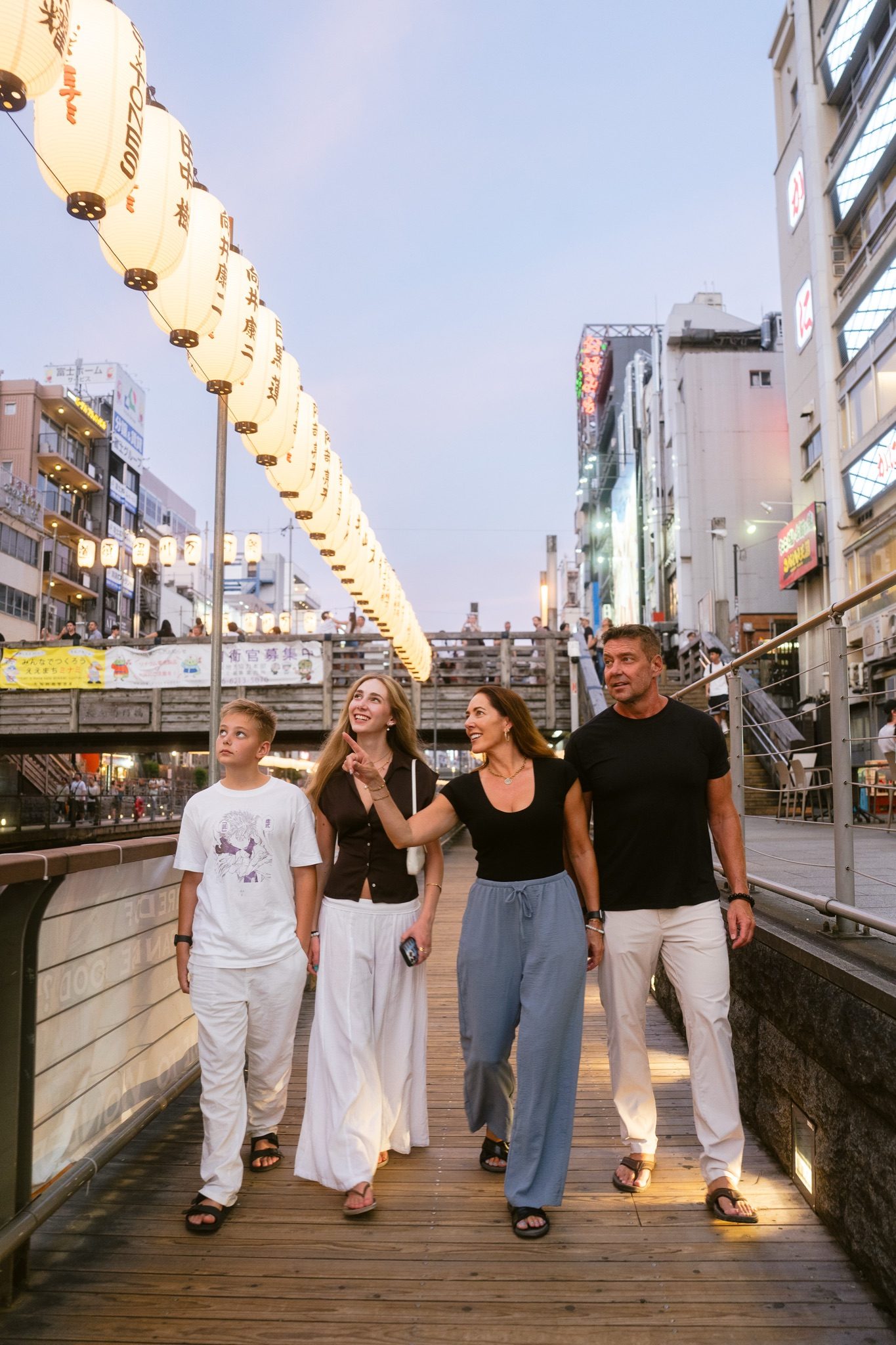 The family walking along the Dotonbori canal at dusk