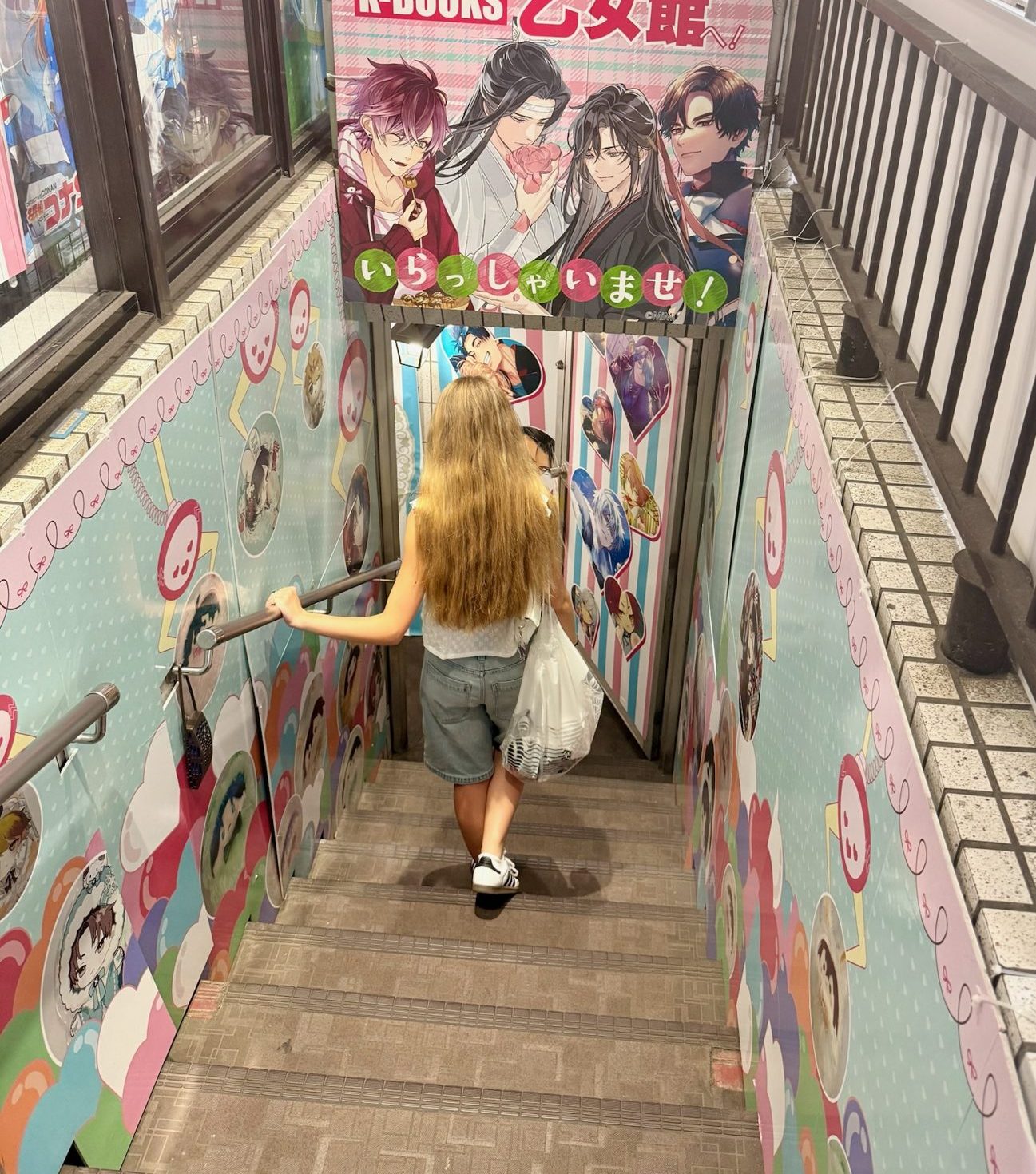 The family's daughter heading down the stairs into an anime shop in Ikebukuro