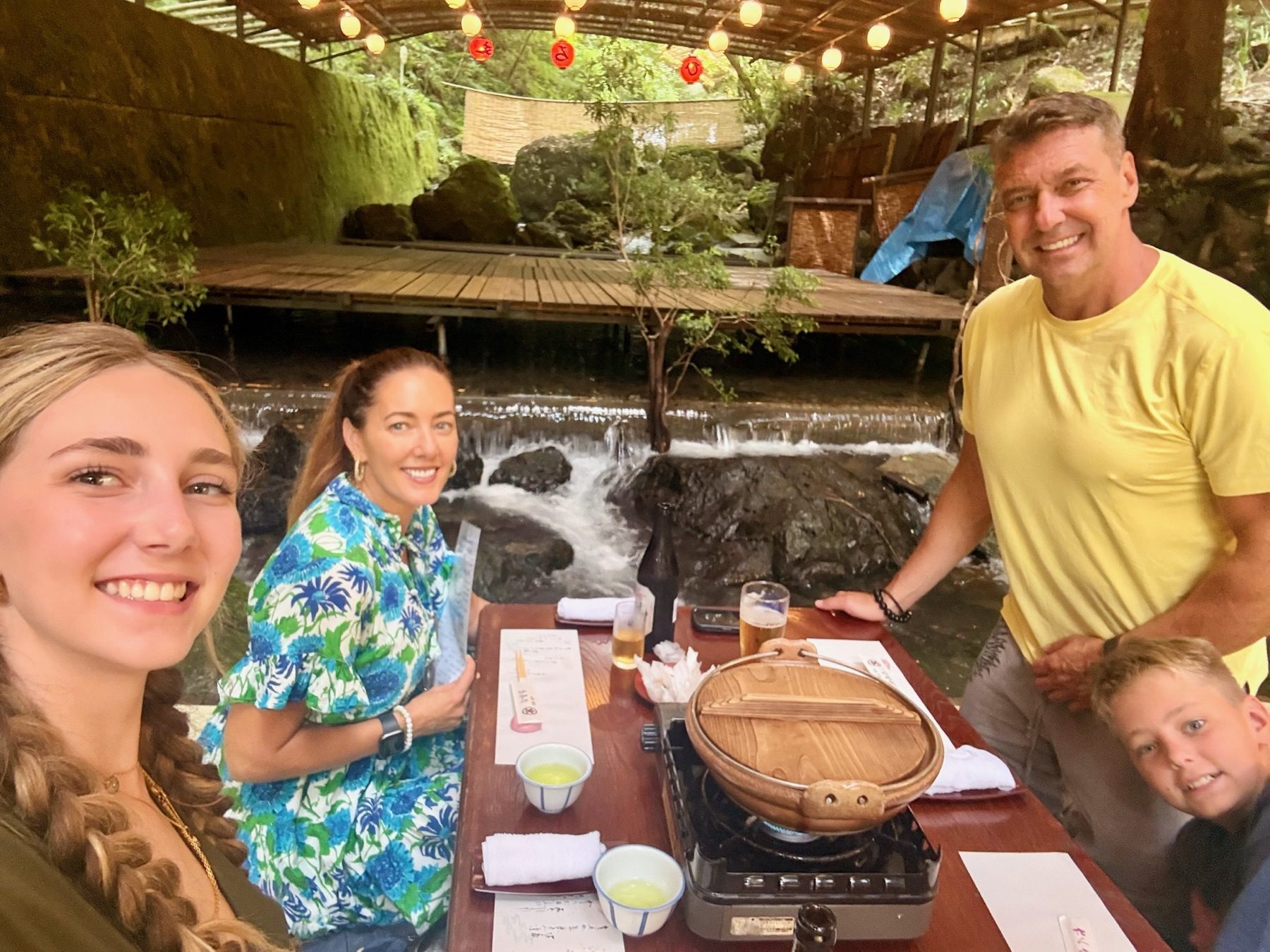 The family at lunch on a wooden platform over the river in Kibune