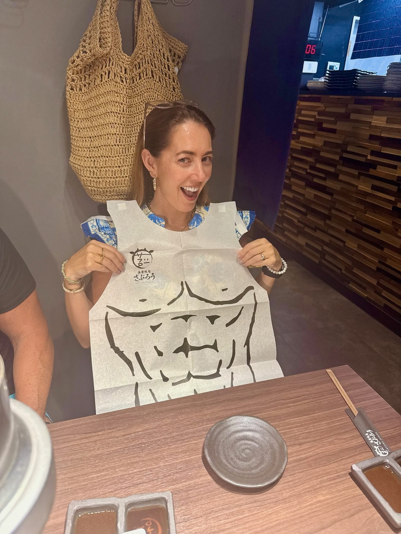 The family's mother in a paper bib at dinner in Osaka